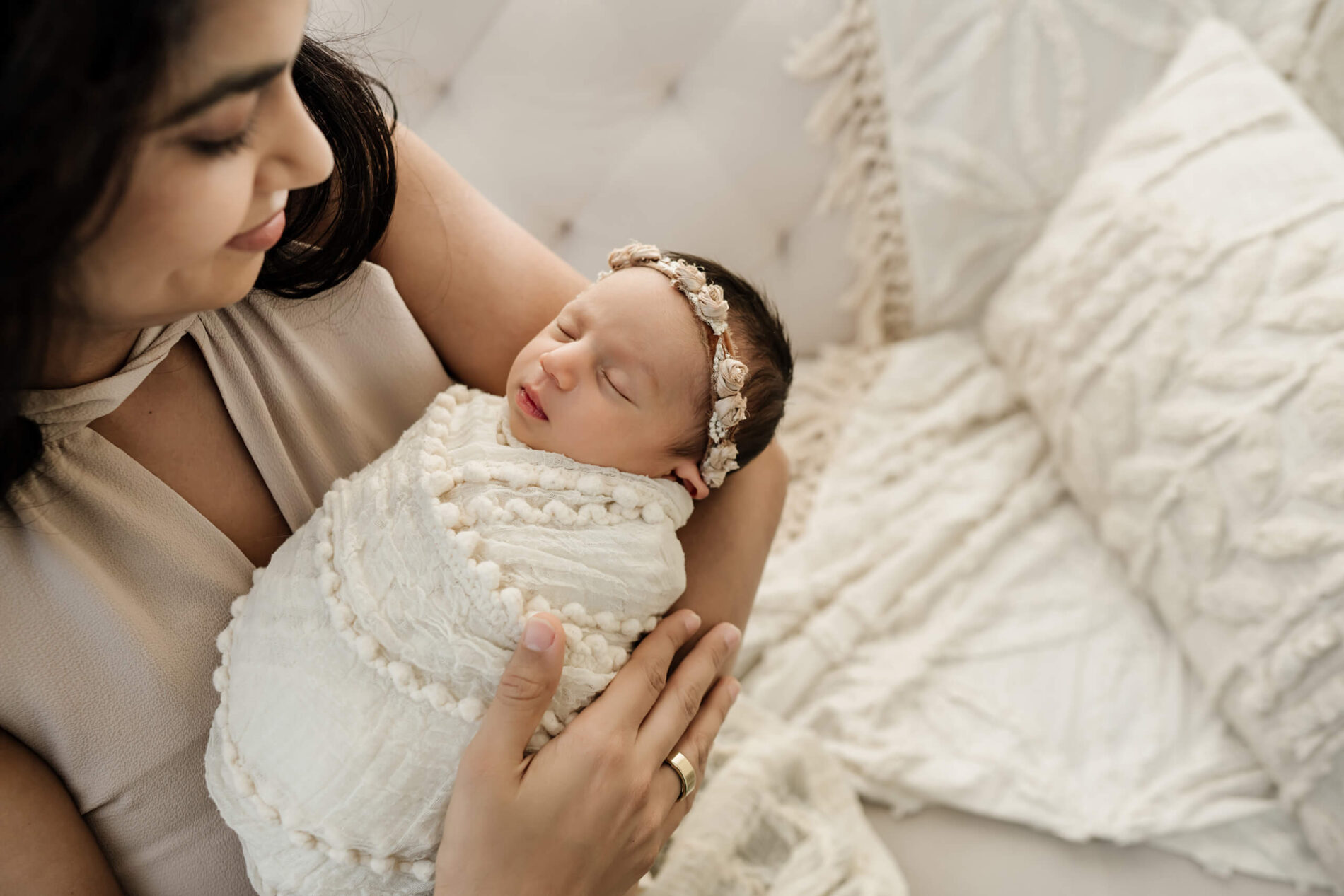 Mom holding newborn daughter during photoshoot in Kirkland studio