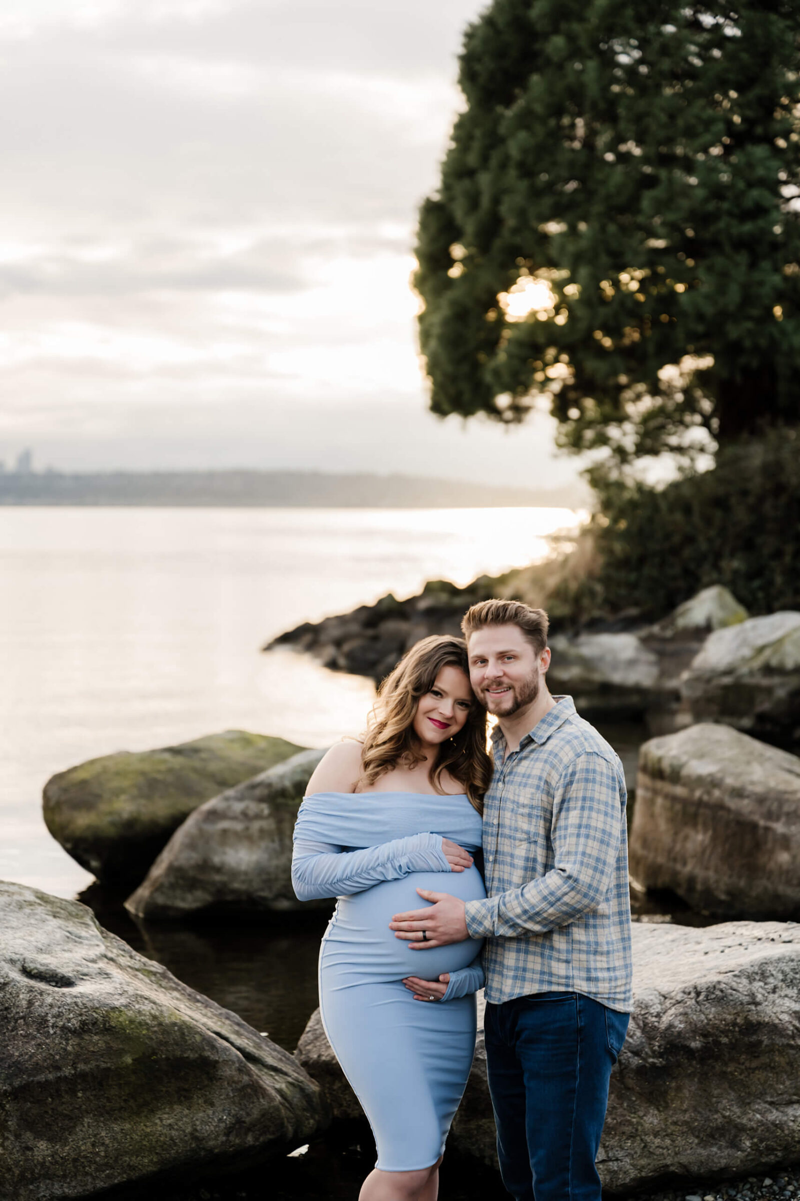 Maternity photographer posing a young couple at the Kirkland Marina Park Public Beach