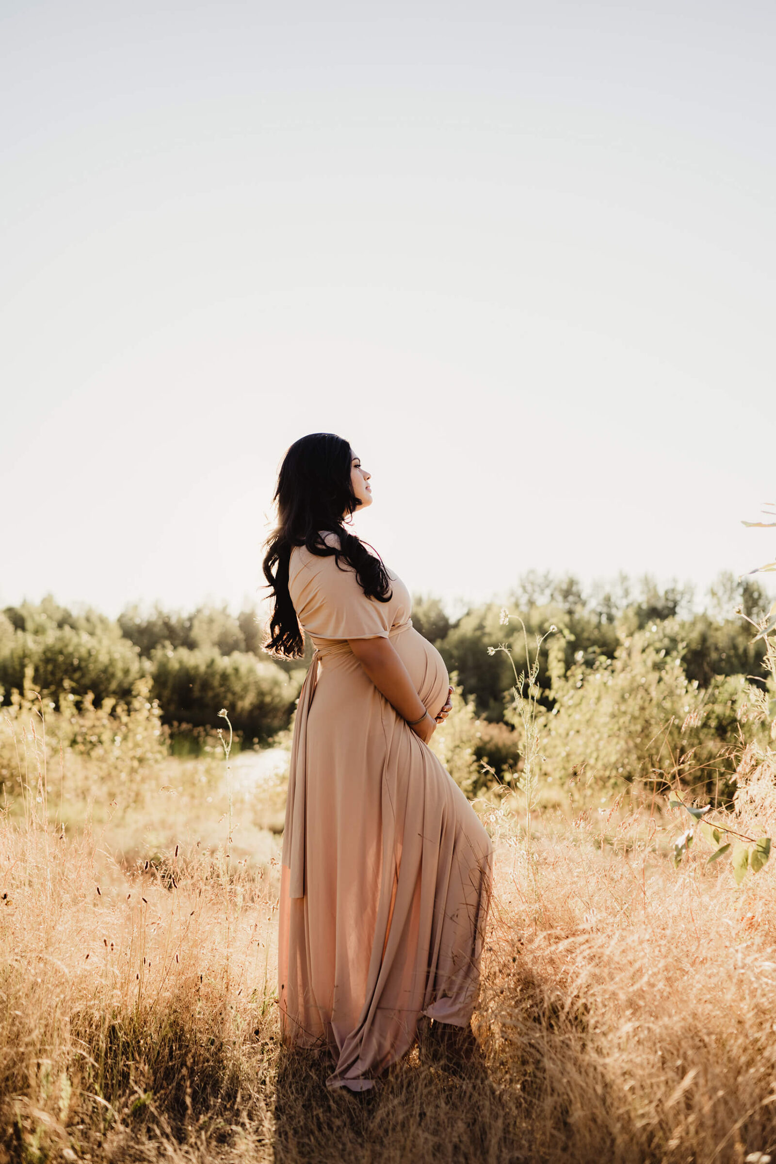 Maternity photoshoot with a pregnant woman in a beautiful gown in a Seattle area during summer