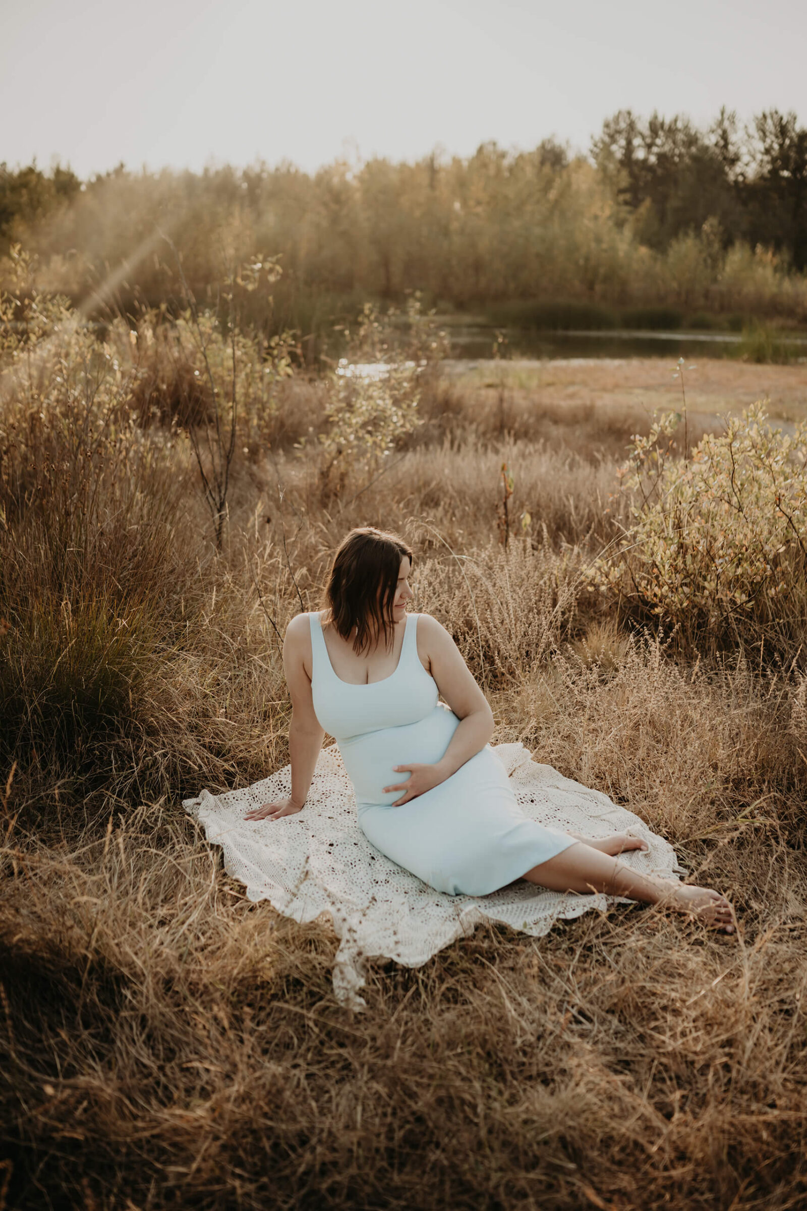 Maternity photographer posing a pregnant woman during photoshoot