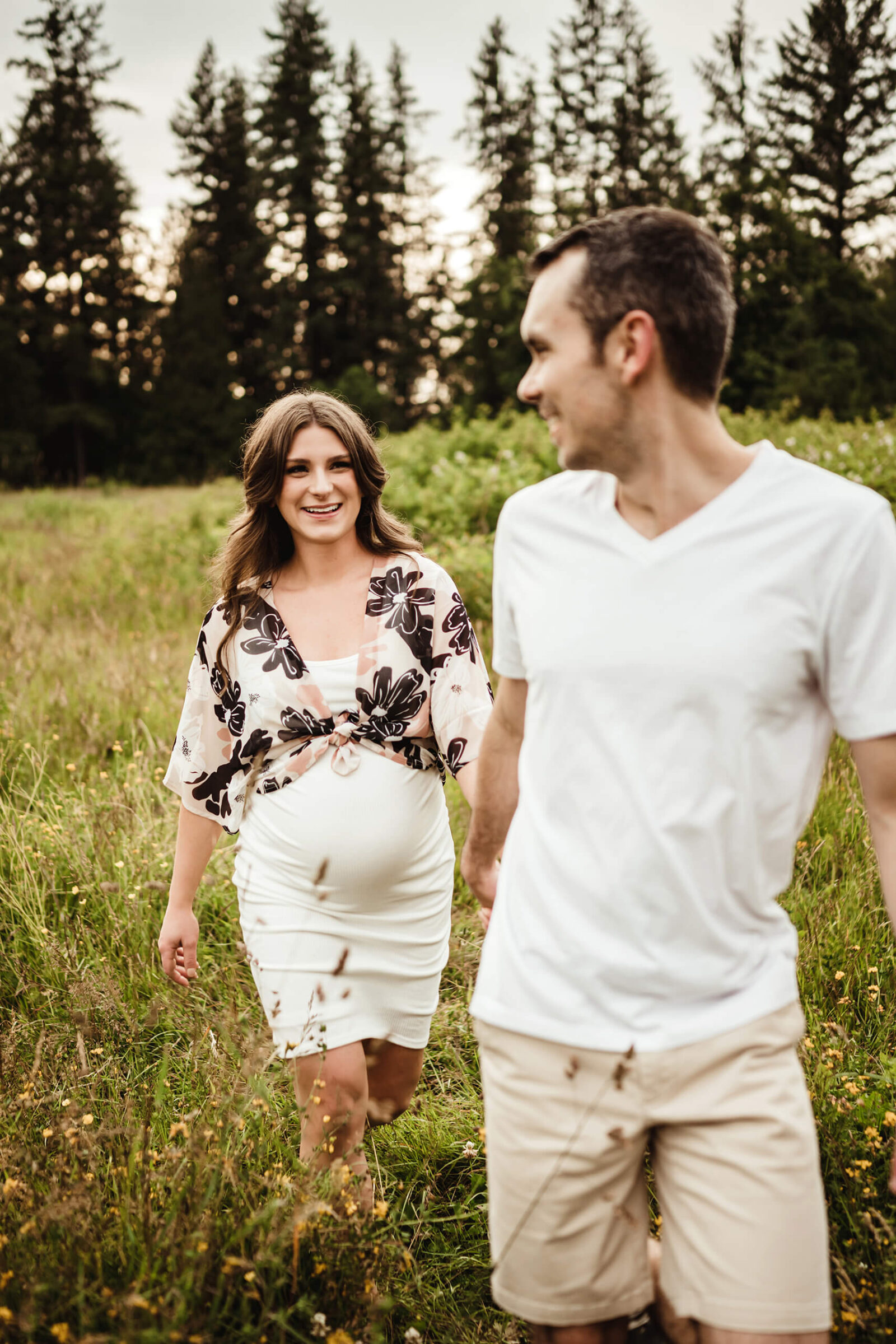 Seattle maternity photographer working with a couple in a field