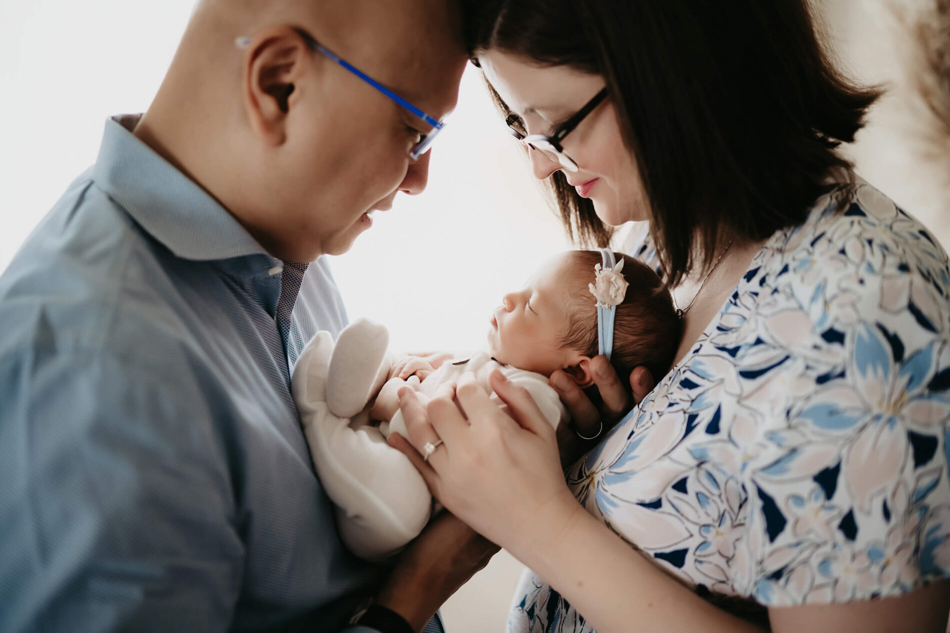 Side view of parents leaning in, baby nestled between them.