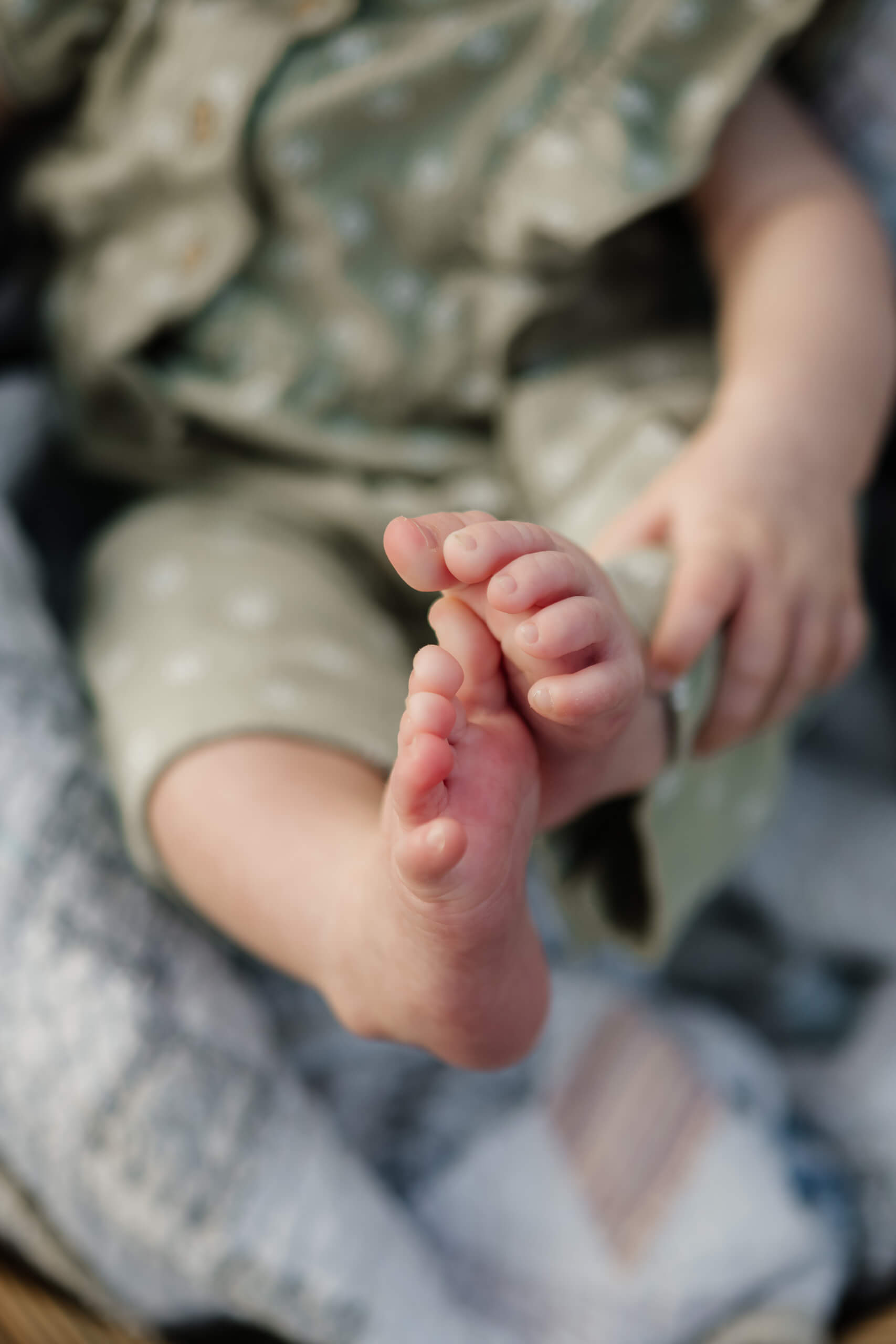 Close-up of tiny baby toes resting on a patterned blanket.