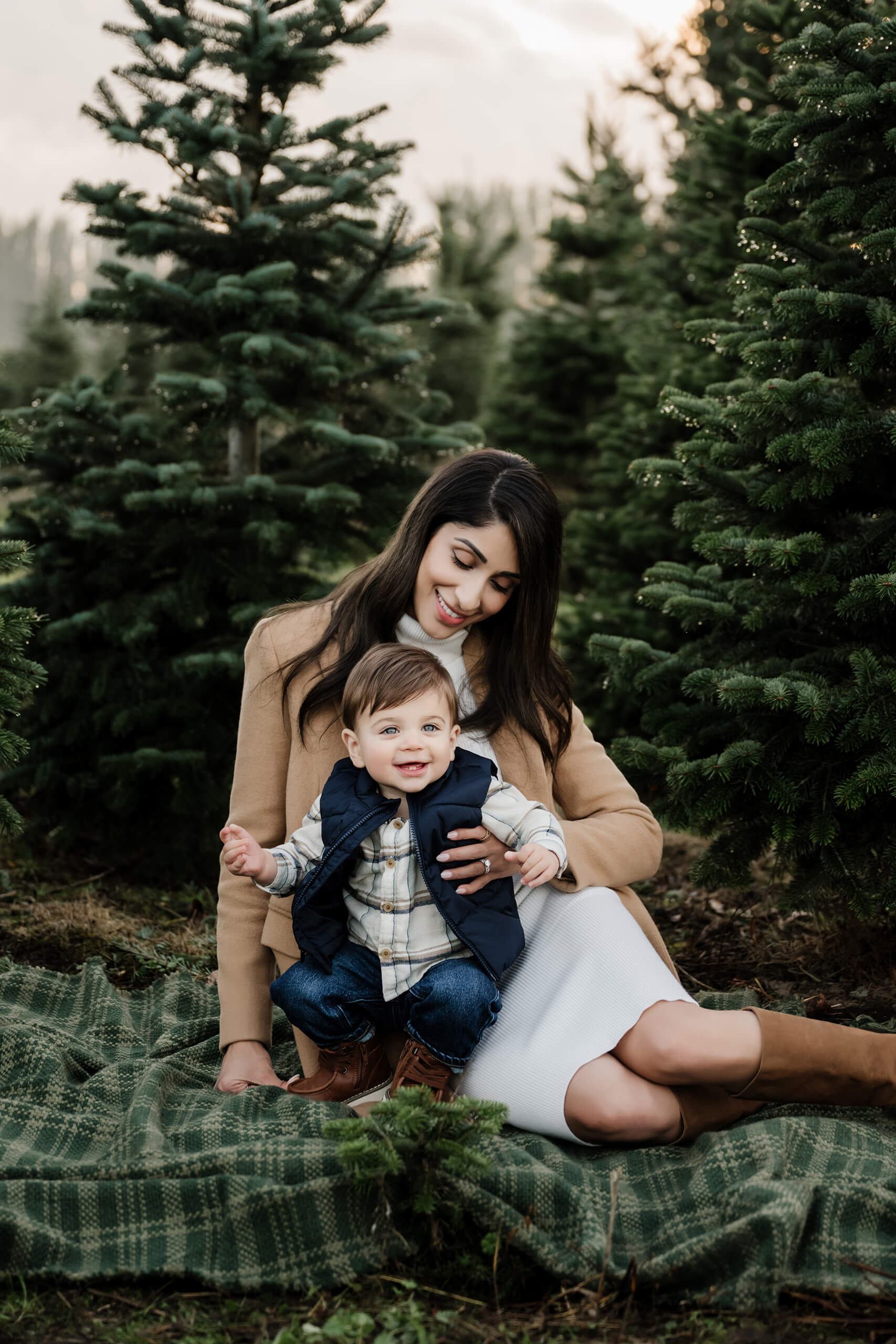 Mother sitting with toddler on blanket – Natural holiday portraits at Seattle Christmas tree farm mini sessions.
