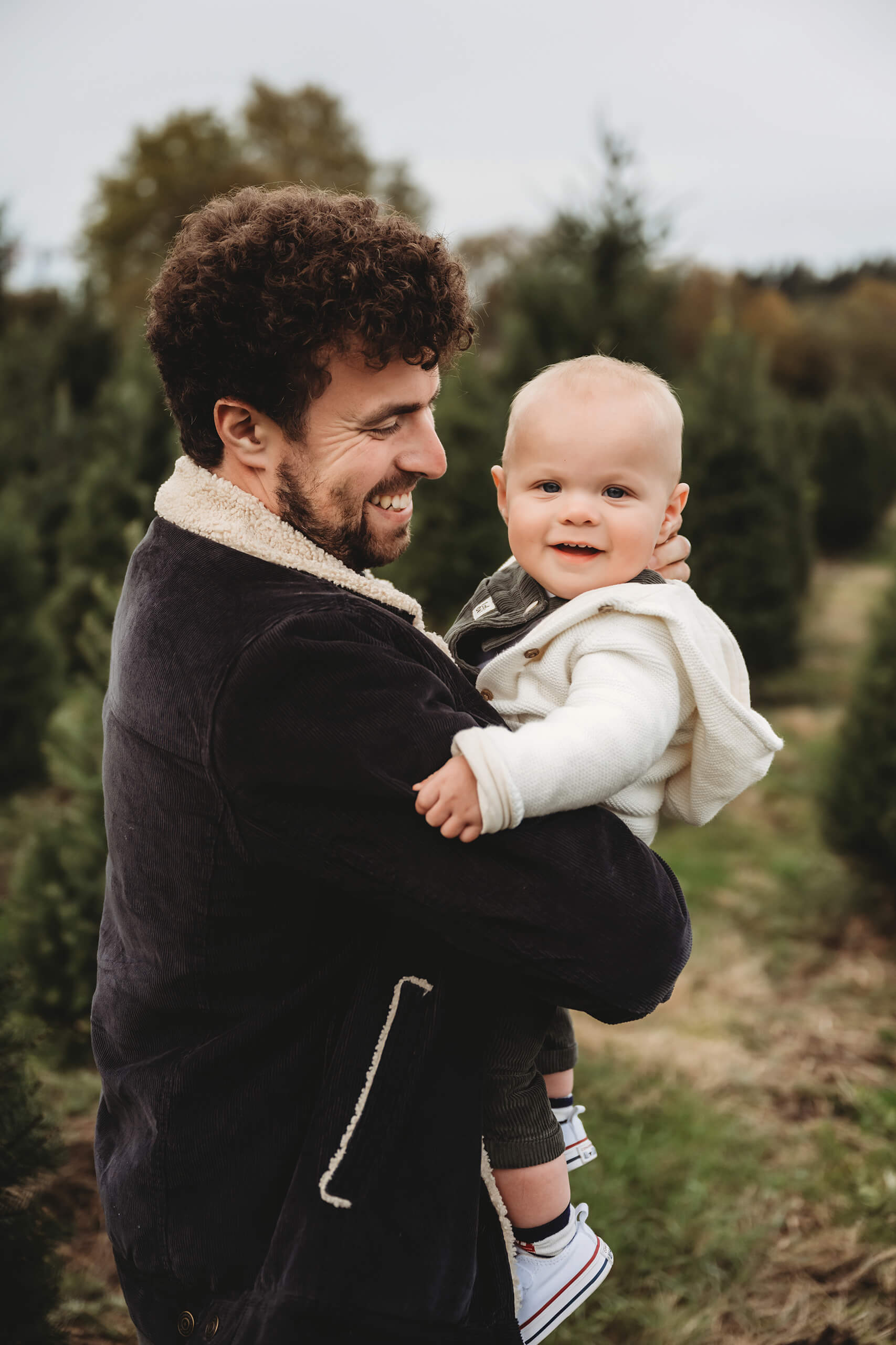 Father holding baby boy – Natural Seattle holiday family portrait at tree farm mini session.