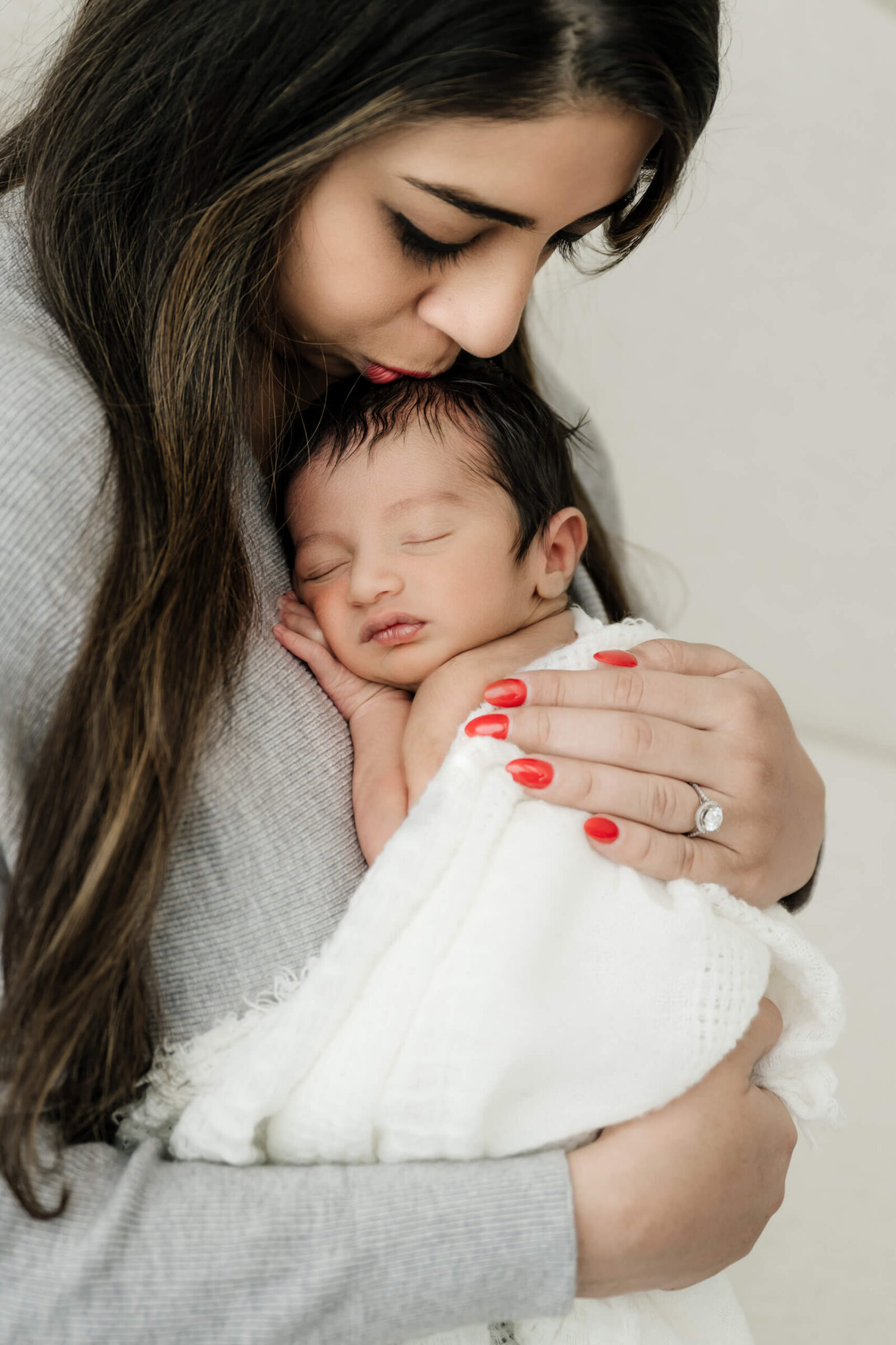 Mother holding newborn baby close during Seattle studio newborn session.