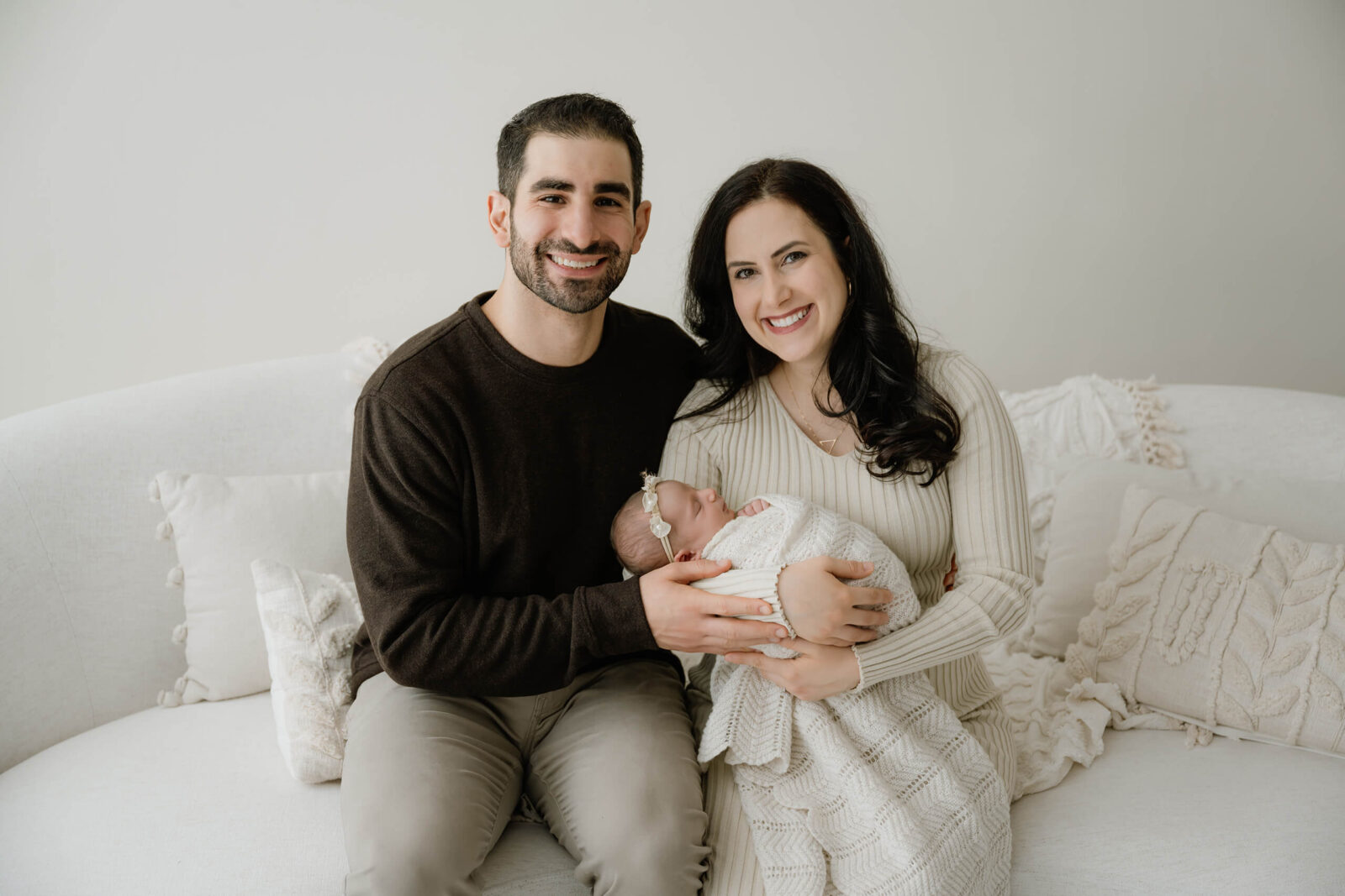 Young happy couple posed naturally during newborn photoshoot in Seattle area studio
