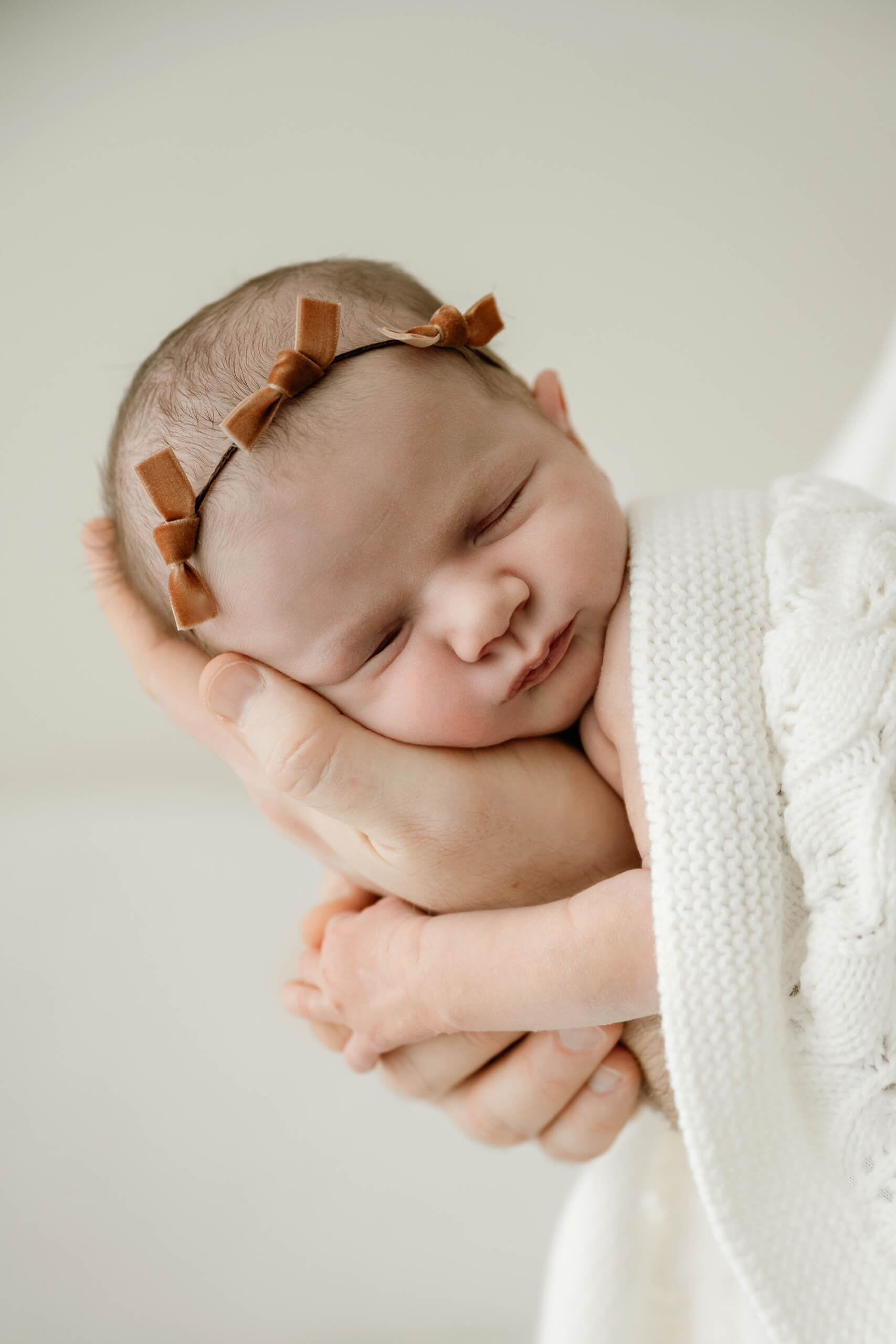 Dad cradles his newborn in his hands wrapped in a soft blanket for Seattle family newborn photography