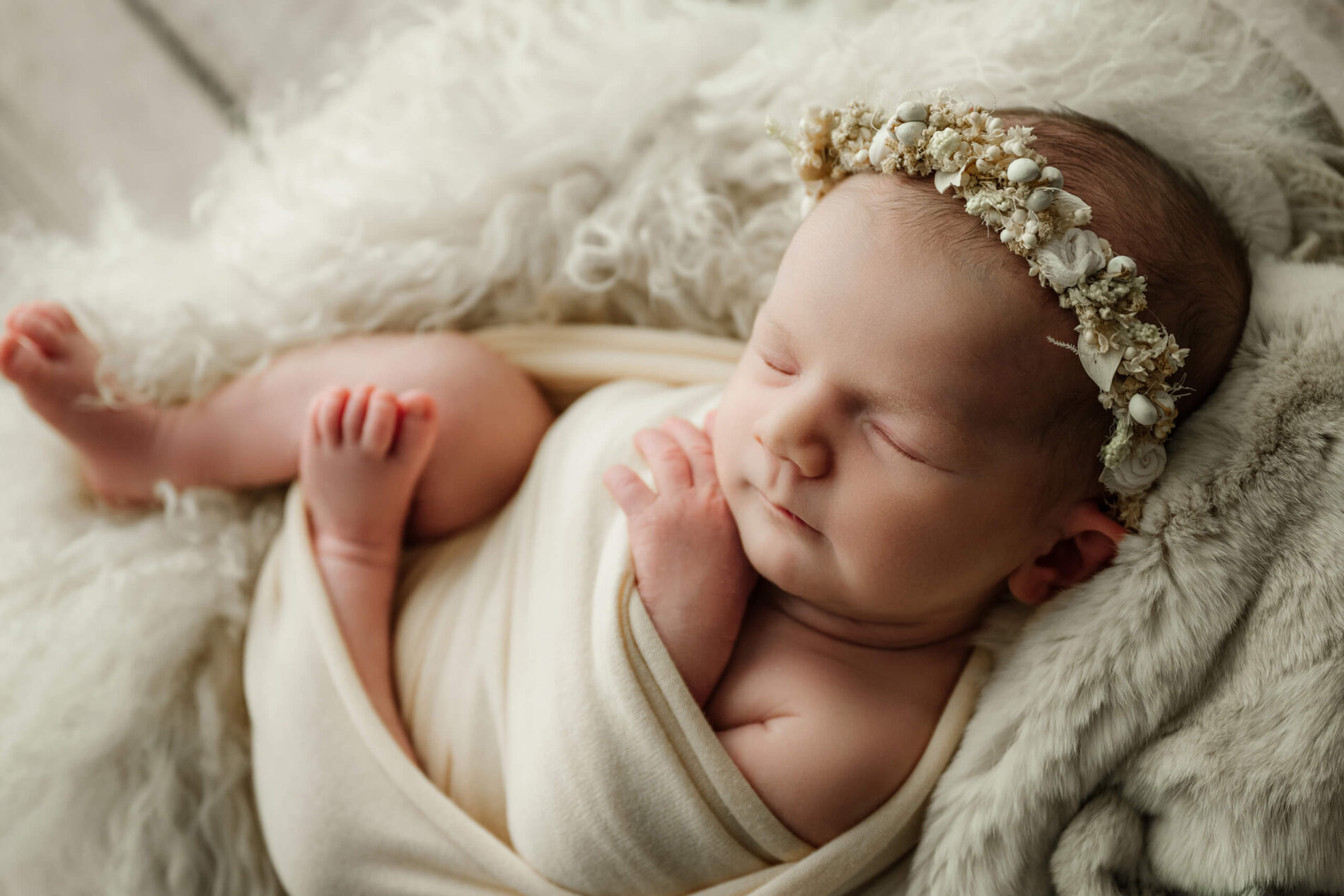 Close up of a swaddled newborn in a floral crown for family newborn photography in Seattle