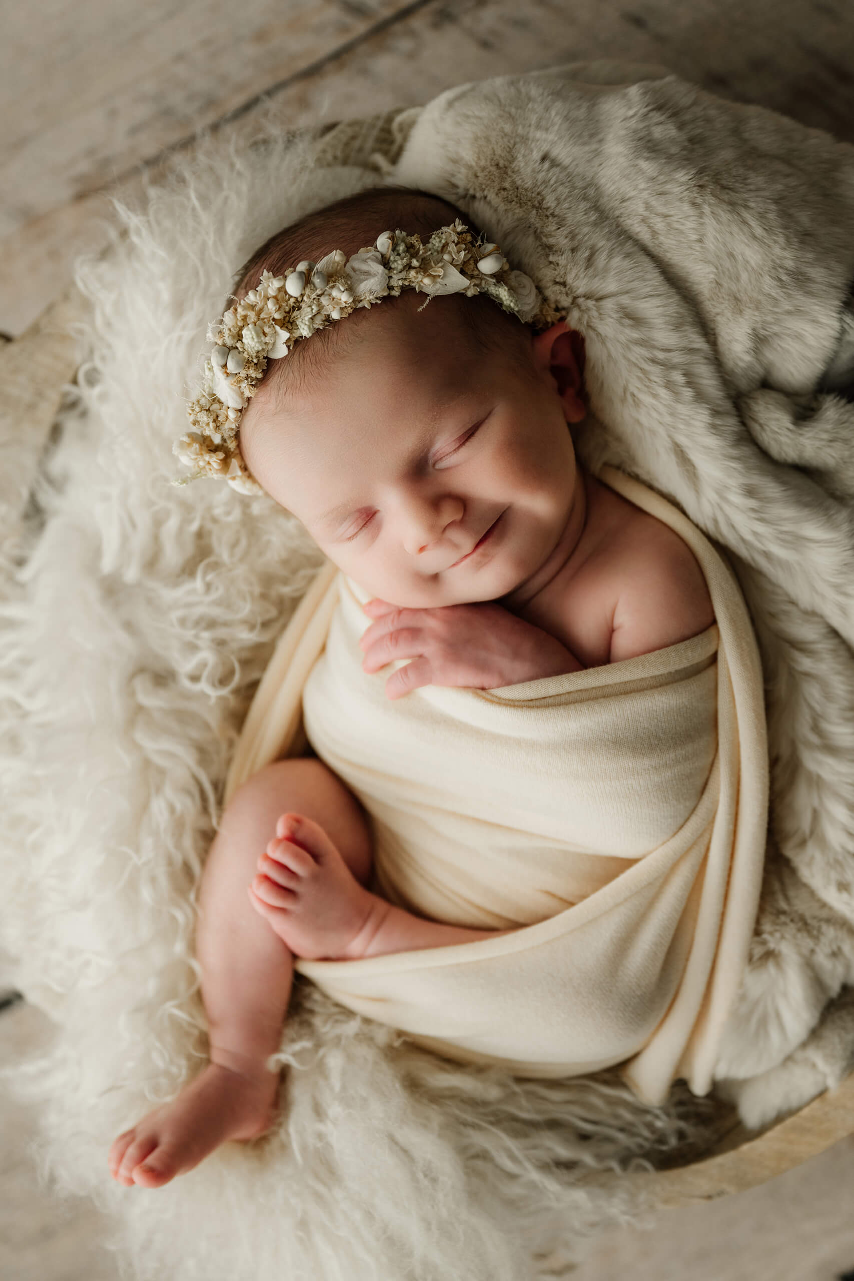 Newborn wrapped and snuggled in a cozy bowl setup during a Seattle newborn family photoshoot