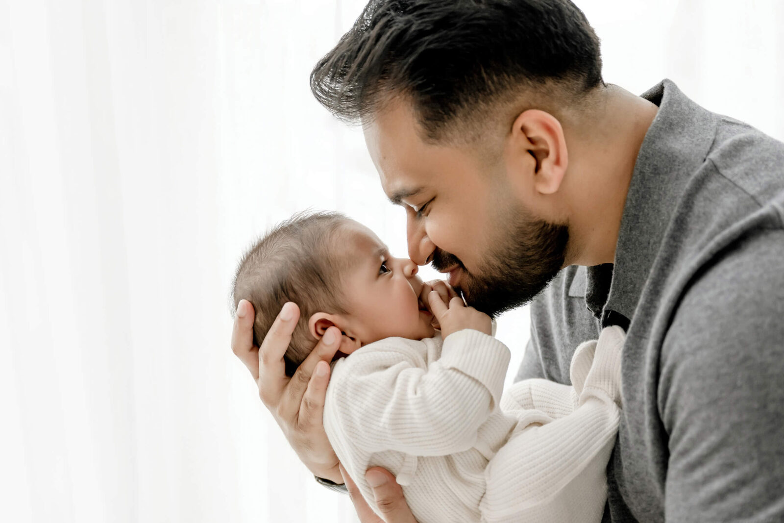 Three month old baby held by parent during a Seattle newborn photoshoot, showing an older newborn session option