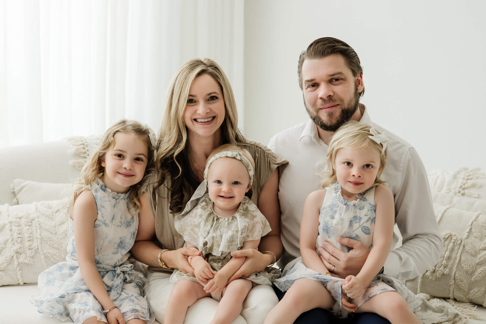 A family of five sitting together in a light-filled studio for a family photography session near Bellevue.