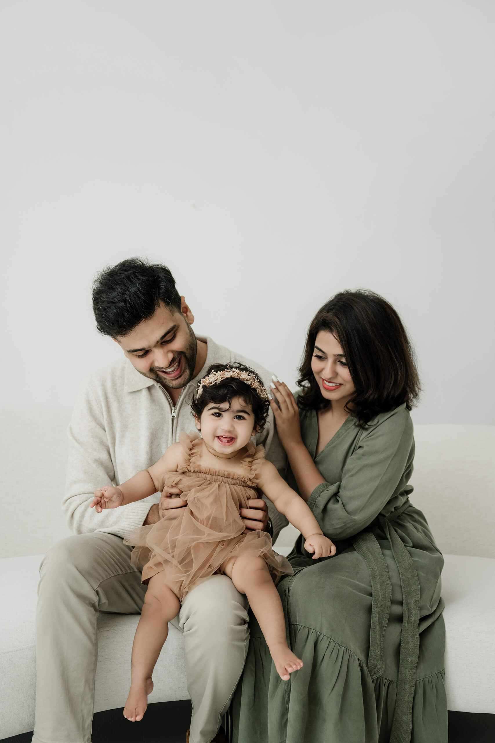Parents holding their baby in a calm, light-filled family studio session near Bellevue.
