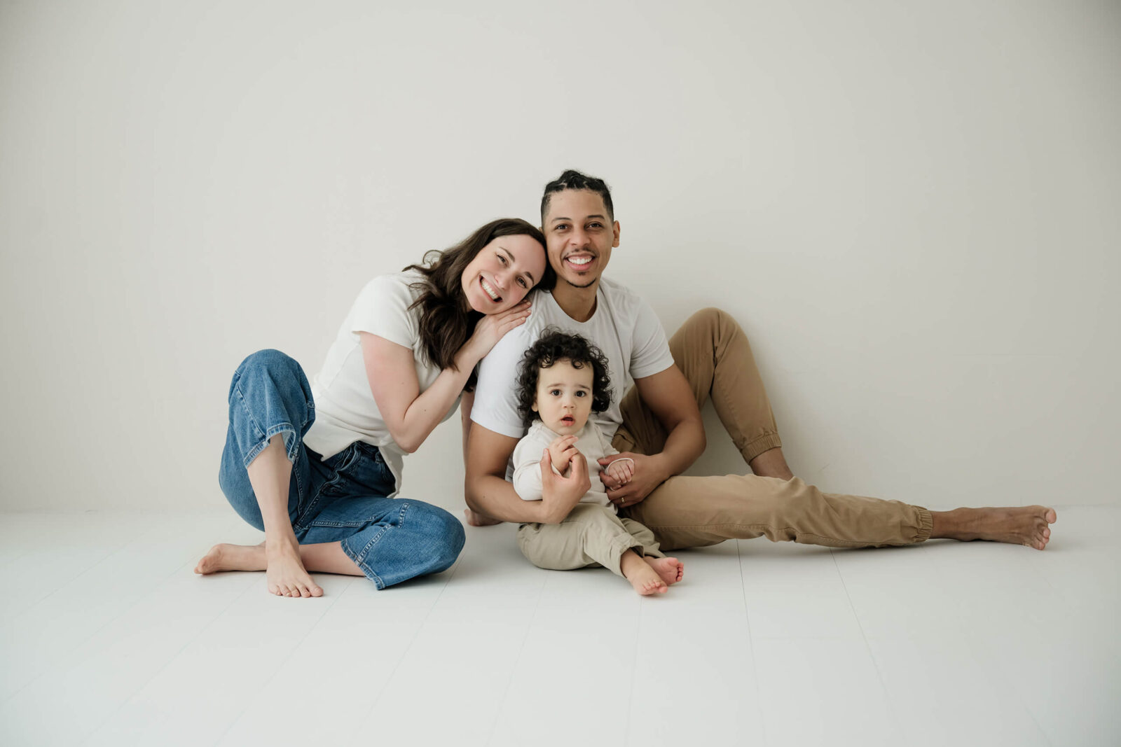 A young family seated on the studio floor in a relaxed family photography session in Seattle.