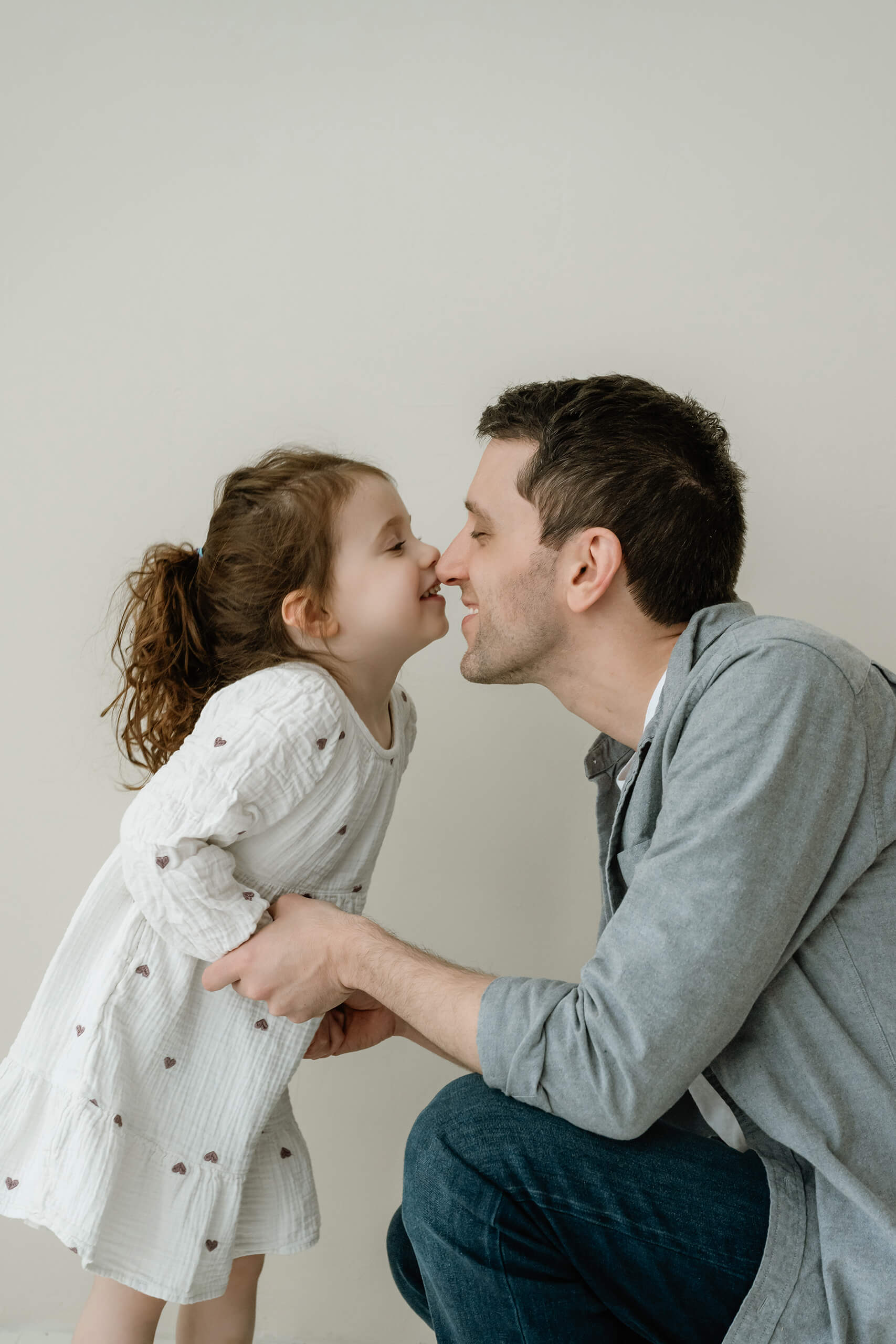 A father sharing a playful nose-to-nose moment with his daughter during a family session near Bellevue.