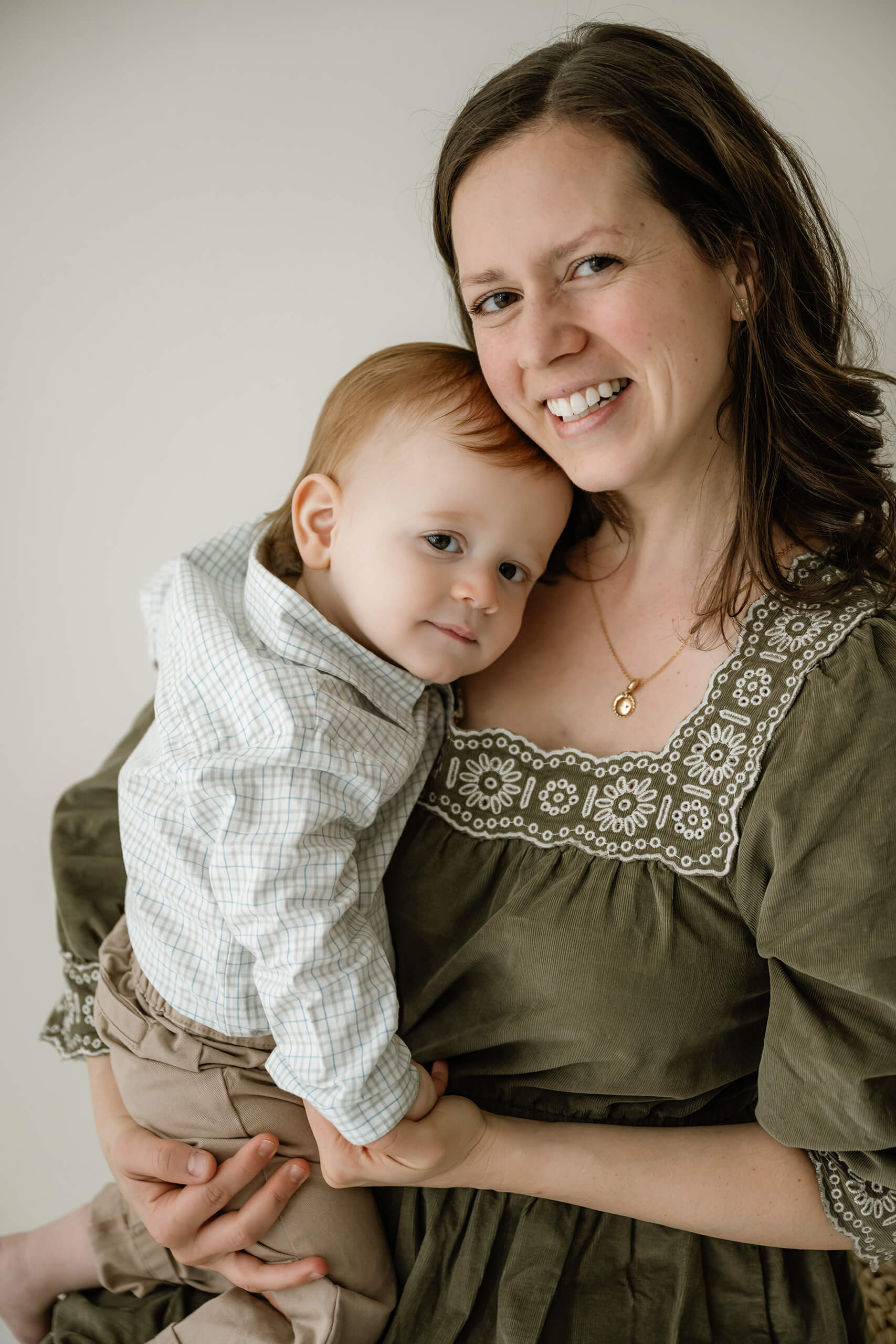 A mother holding her baby boy close during a relaxed family studio session near Bellevue.