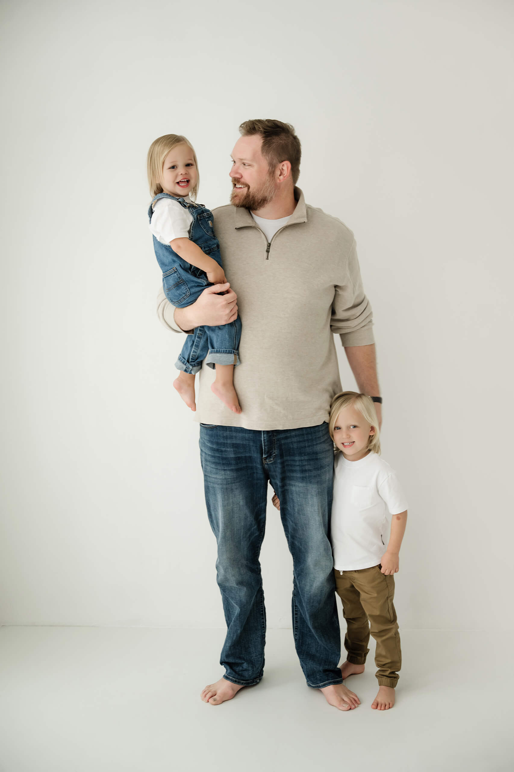 A father holds his two children during a timeless family photography session in Kirkland.
