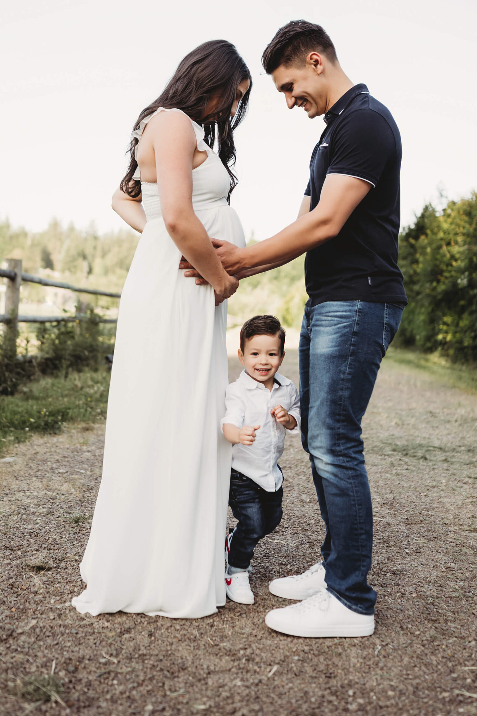 Growing family with a toddler during a natural outdoor maternity session.