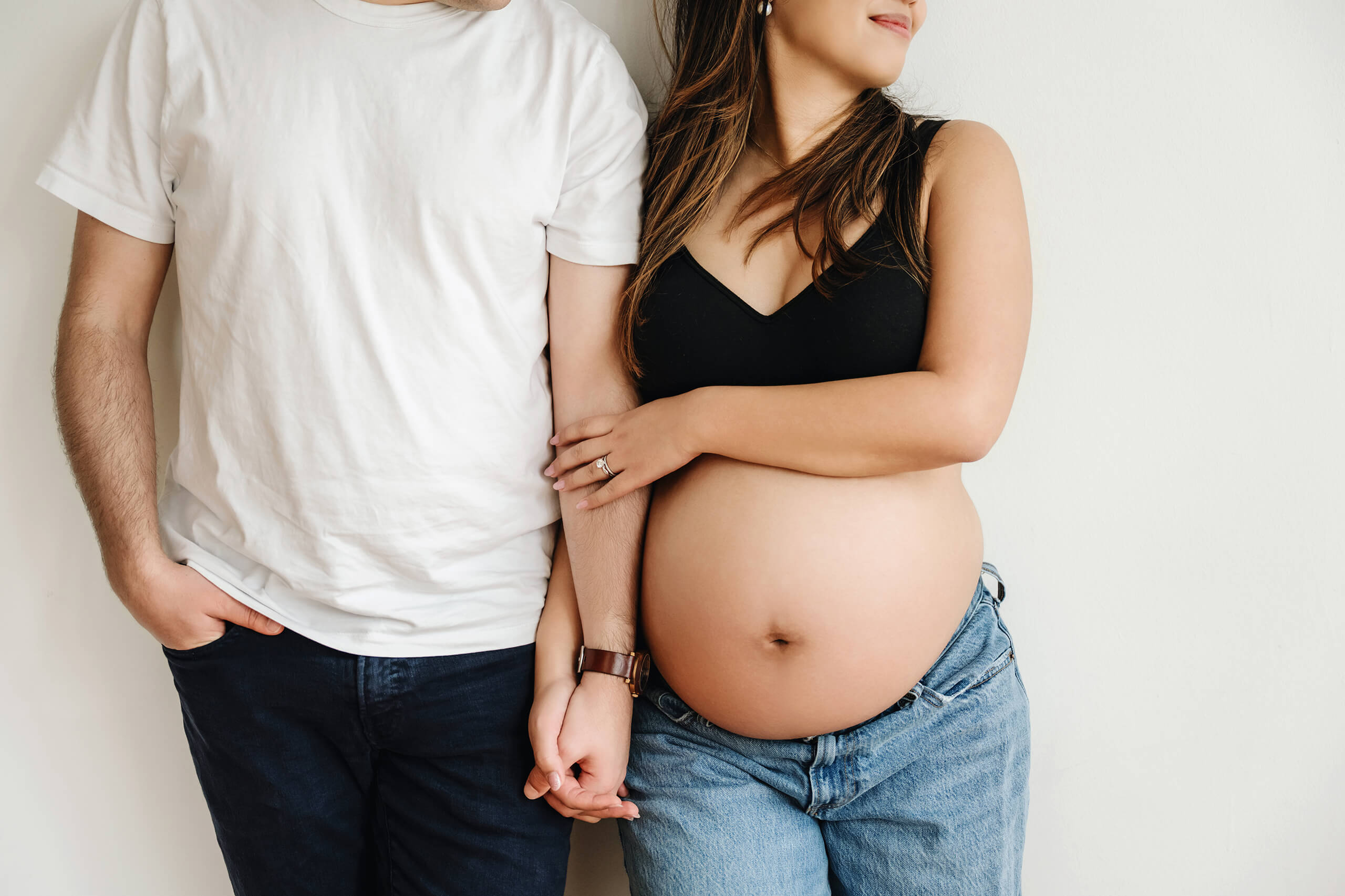Expecting couple holding hands during a simple studio maternity session