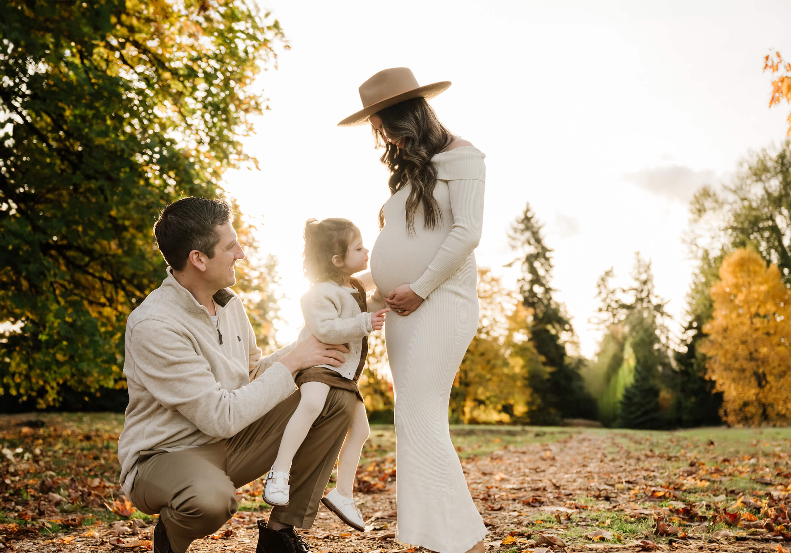 Pregnant mother with her partner and toddler during a Bellevue maternity photography session in autumn.