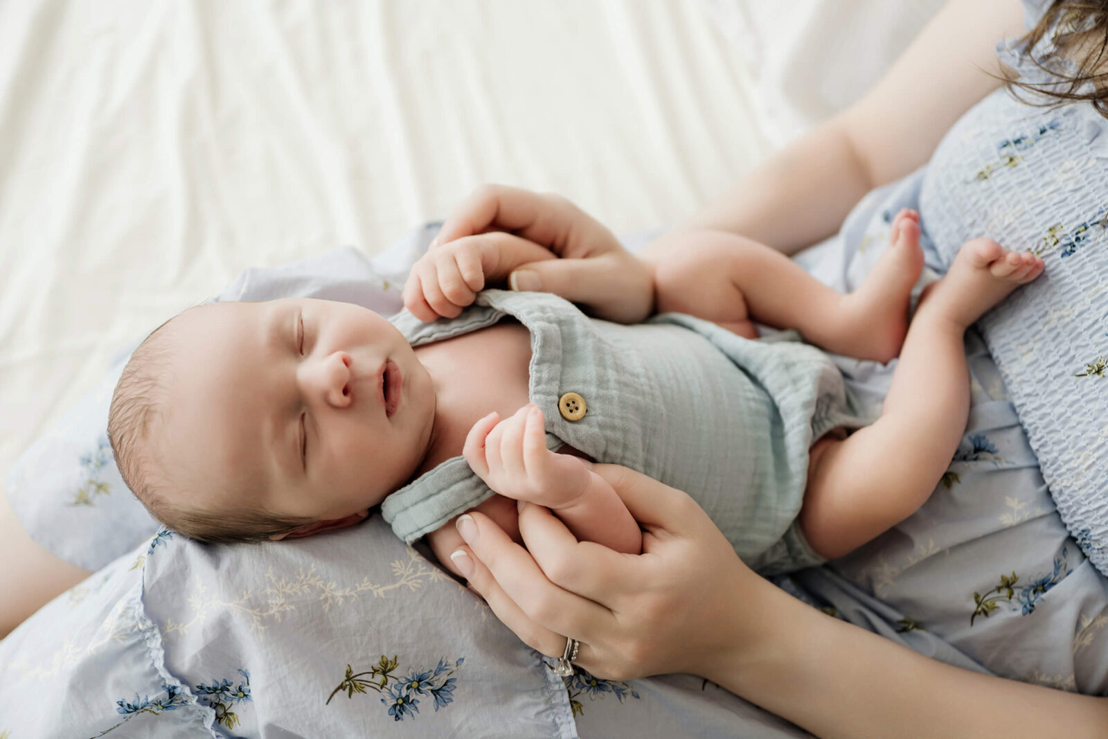 Sleeping newborn resting in a parent’s hands during a soft Bellevue newborn photography session.