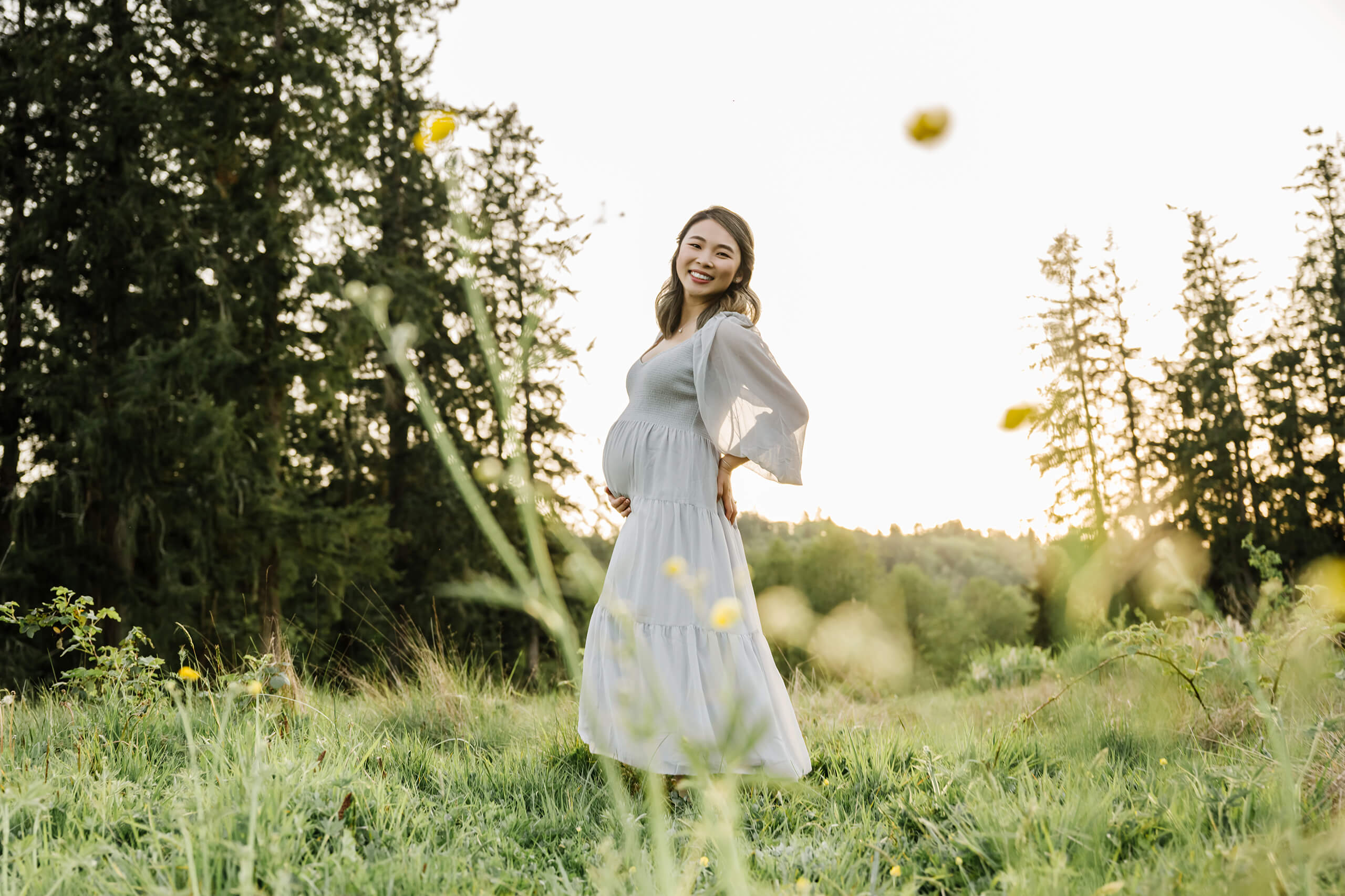 Pregnant mother standing in a green field during a natural Sammamish maternity photography session.