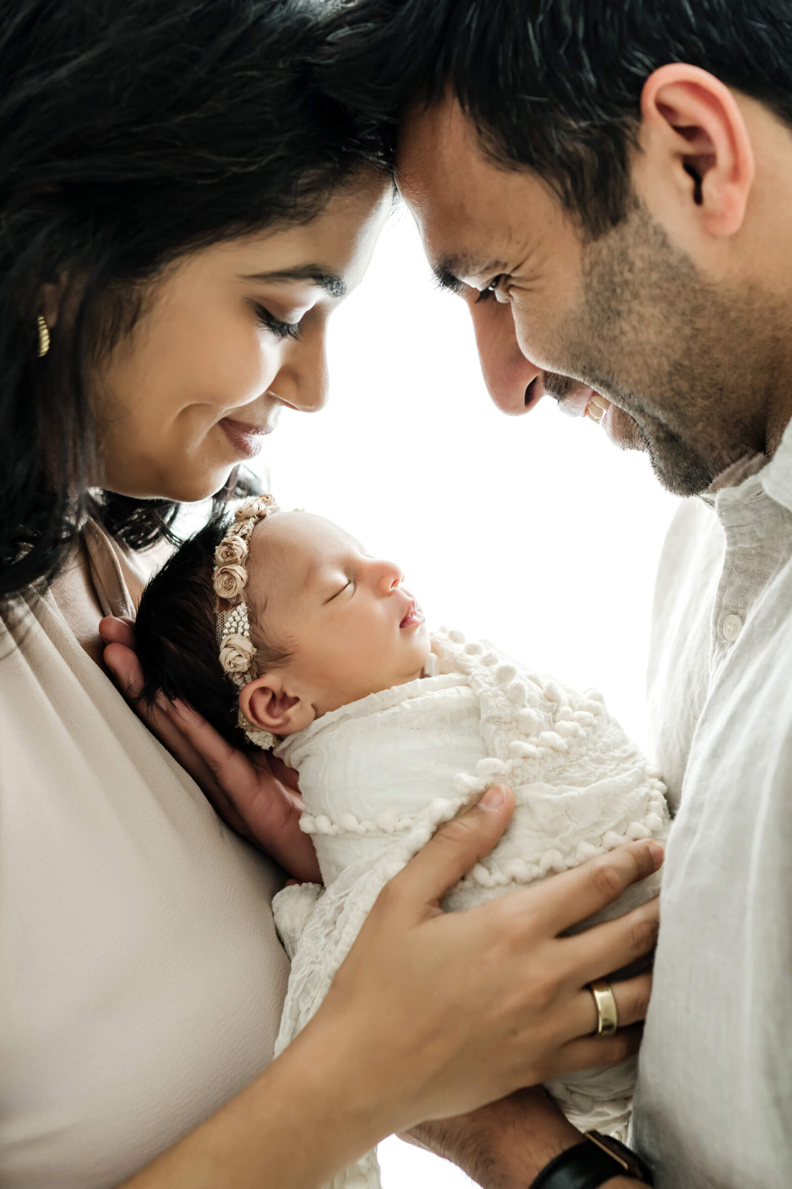 Parents smiling down at their sleeping newborn during a close Sammamish newborn photography session.