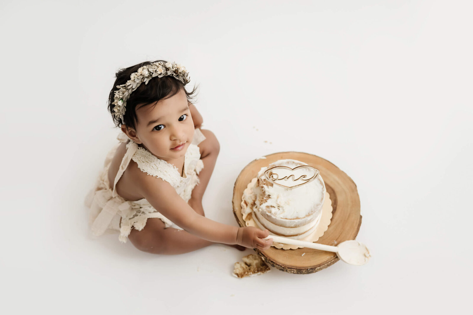 Baby girl enjoying a first birthday cake smash photography session at Lana Sky Photography's Kirkland studio near Seattle.