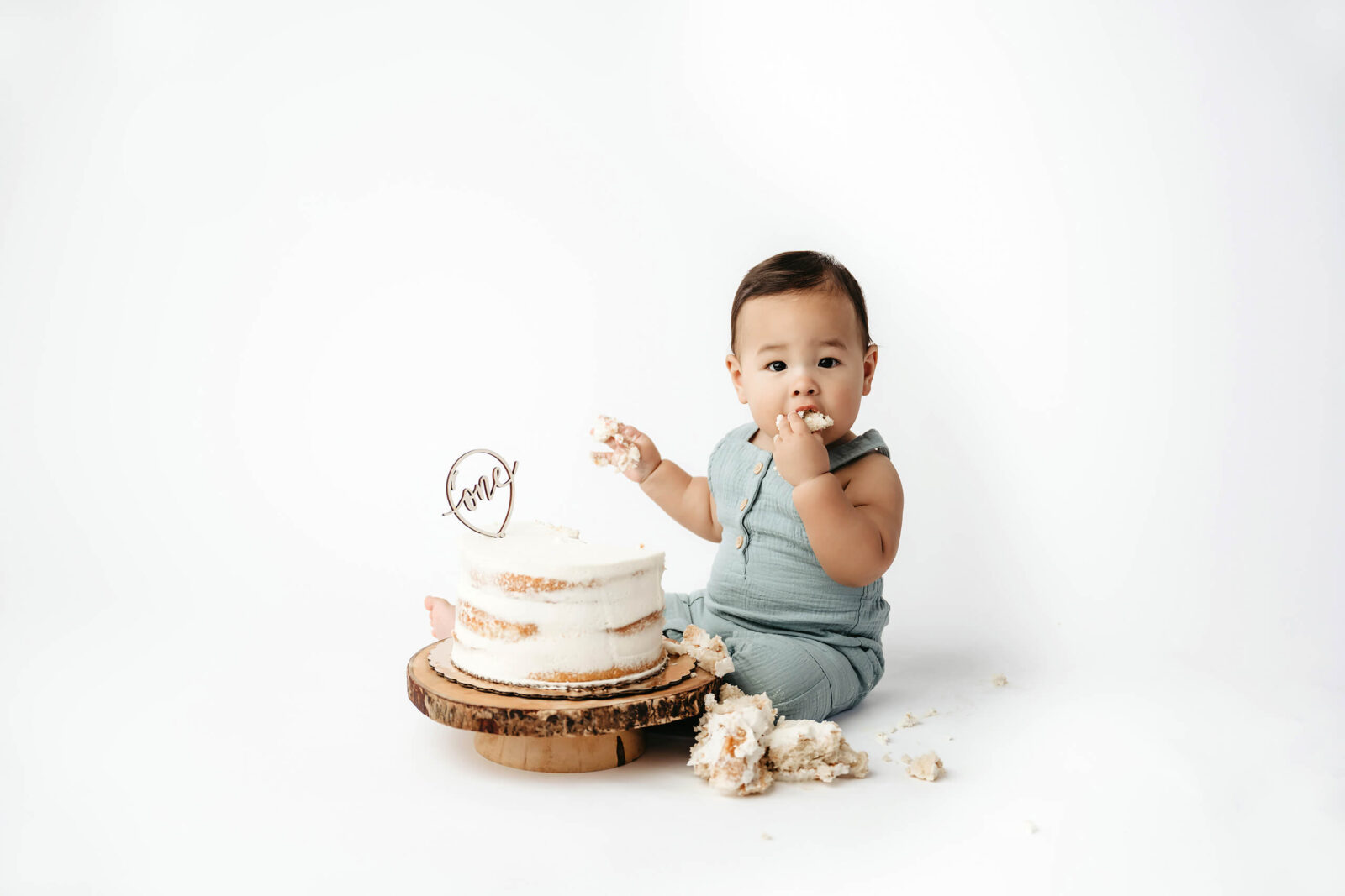 Baby boy enjoying a first birthday cake smash photography session at Lana Sky Photography's Kirkland studio near Seattle.