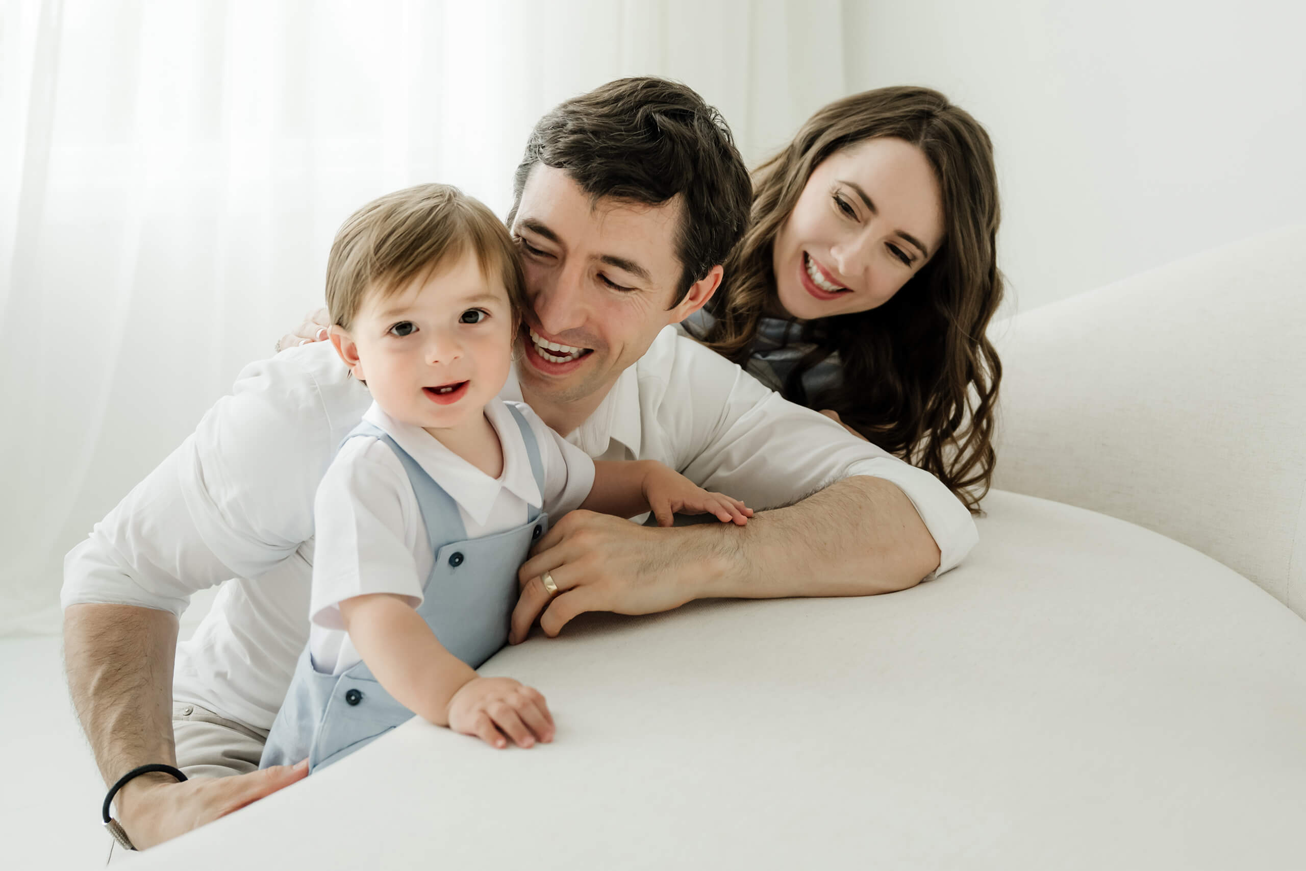 Parents smiling with their one-year-old during a first birthday milestone family photo session at Lana Sky Photography's Kirkland studio near Seattle.