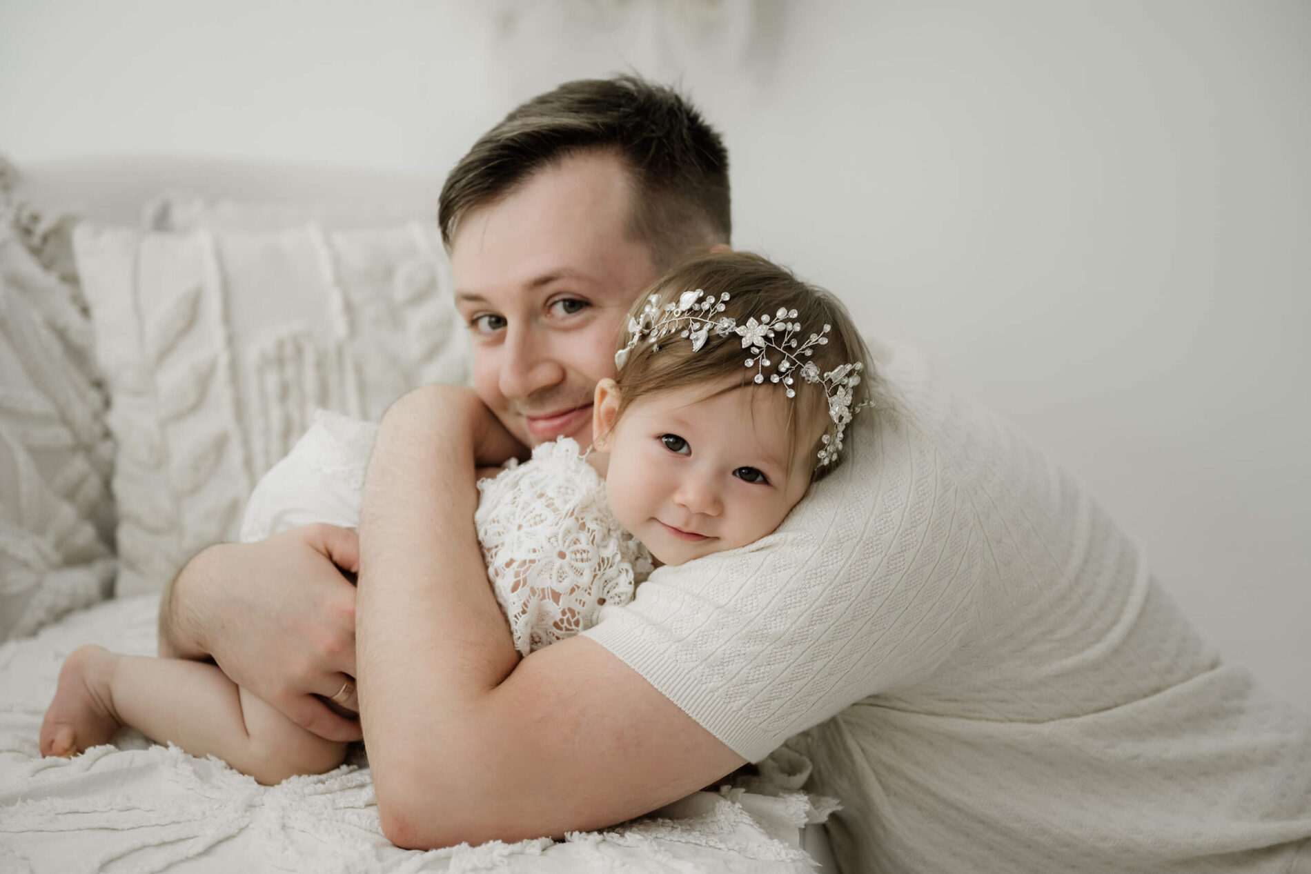 Father cuddling his one-year-old daughter during a first birthday milestone photo session at a Kirkland studio near Seattle.