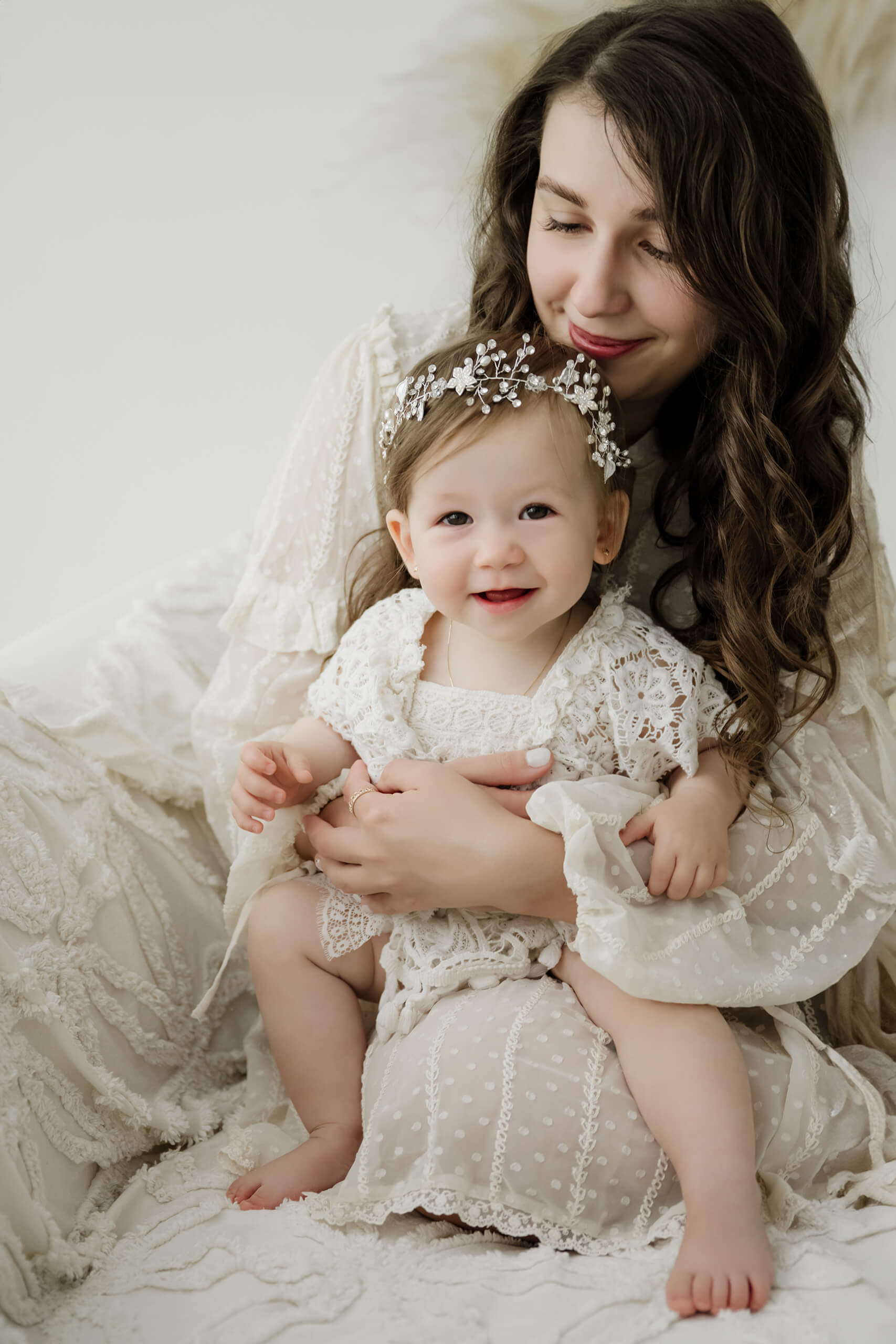 Mother holding her smiling one-year-old daughter during a Seattle first birthday milestone photography session.