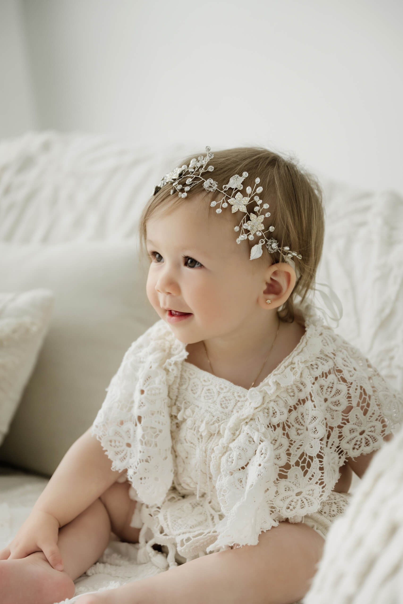 One-year-old girl in a white lace outfit during a simple first birthday milestone portrait session in Kirkland.