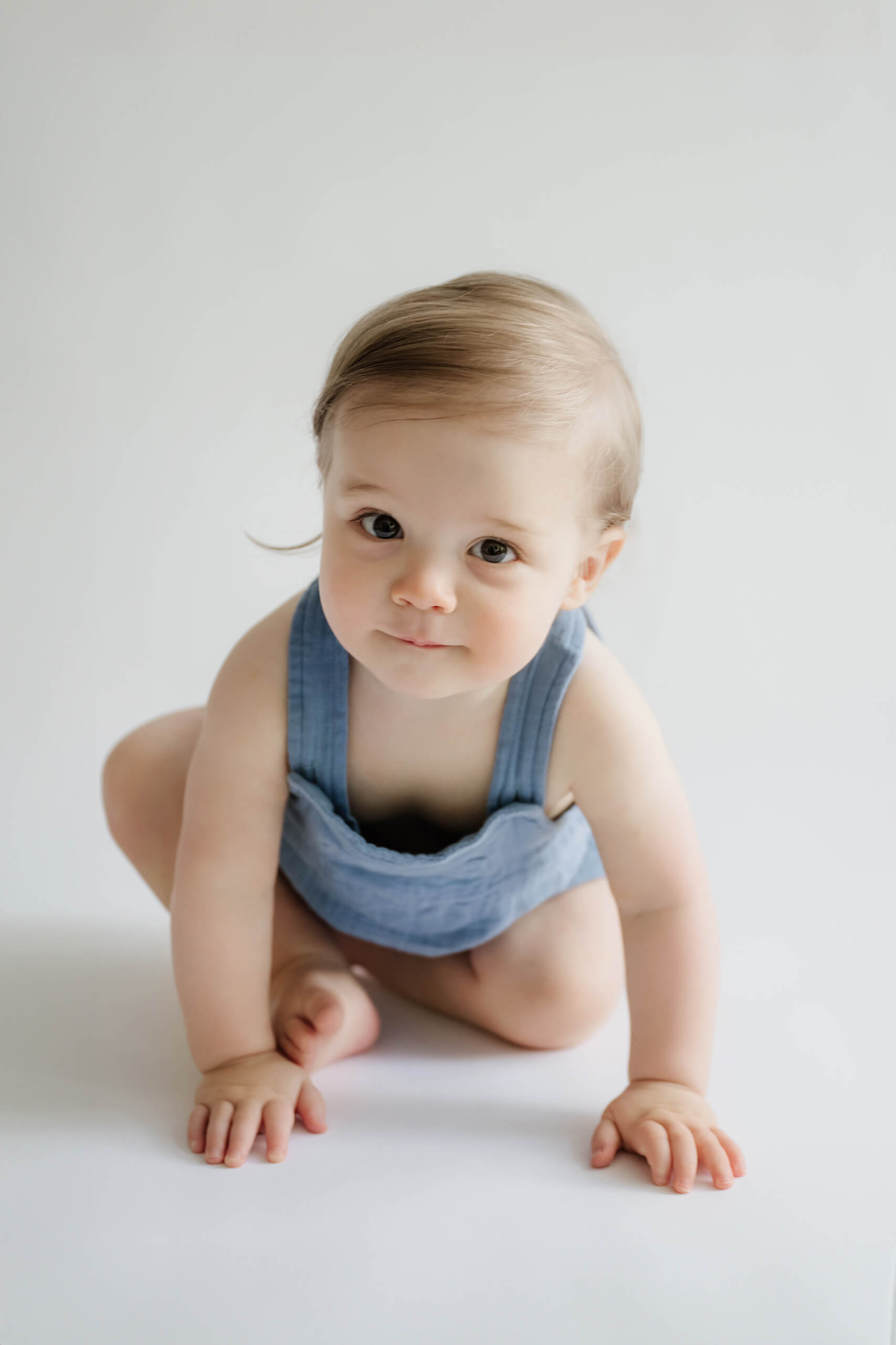 One-year-old crawling toward the camera during a Seattle first birthday milestone photo session.